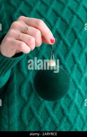 Donna che indossa verde tenente verde bauble Foto Stock