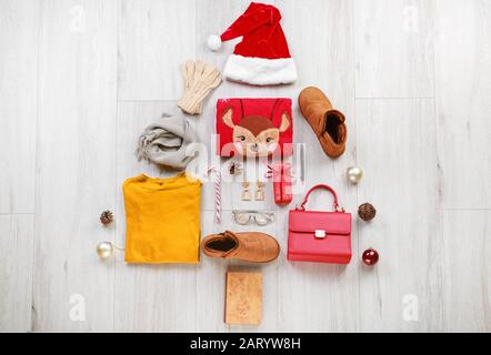 Albero di Natale fatto di vestiti invernali e accessori su sfondo di legno Foto Stock