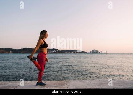 Donna che si allunga dal mare Foto Stock