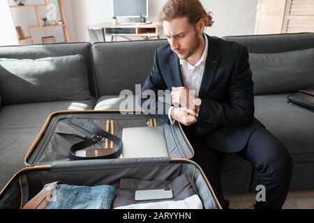 Un giovane uomo d'affari che si mette in viaggio a casa Foto Stock