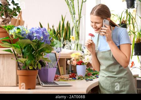 Fioraio tenendo ordinare per telefono in negozio Foto Stock