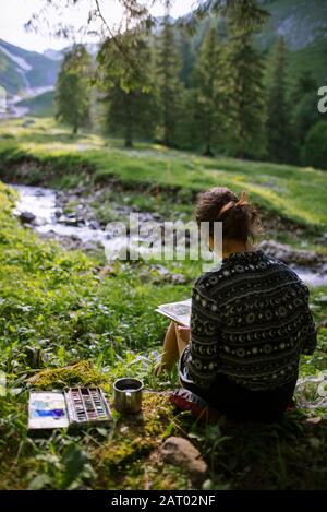 Donna pittura con acquerelli di fiume in Appenzell, Svizzera Foto Stock