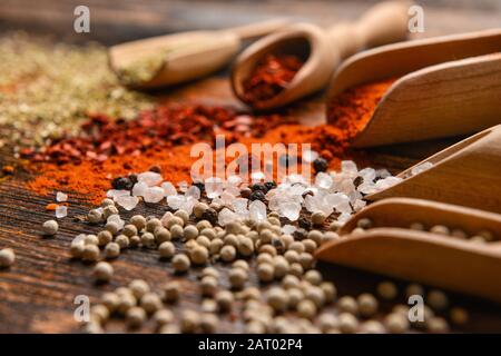 Sessole con diverse spezie su sfondo di legno Foto Stock