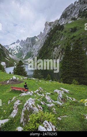 Donna seduta su panchina in montagna ad Appenzell, Svizzera Foto Stock