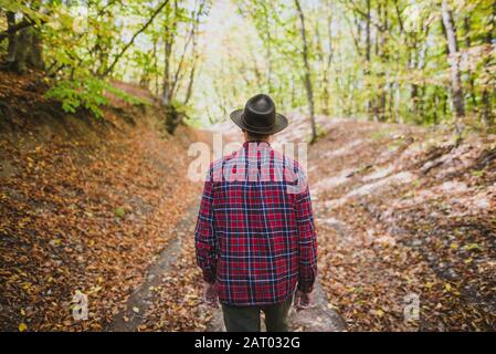 Uomo che indossa una camicia rossa nella foresta Foto Stock