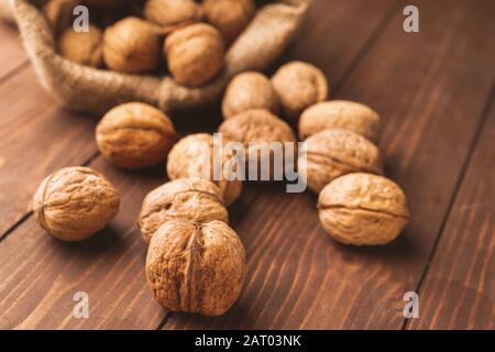 Sacco con gustosi noci sul tavolo di legno Foto Stock