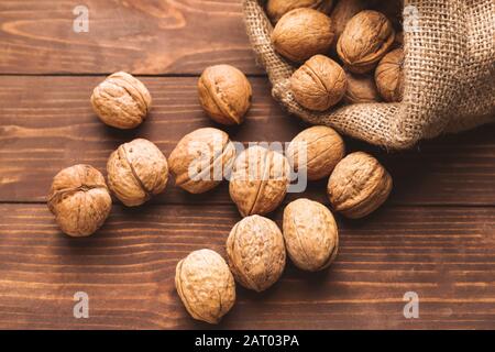 Sacco con gustosi noci sul tavolo di legno Foto Stock