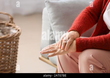 Senior donna che soffriva di dolori al polso a home Foto Stock