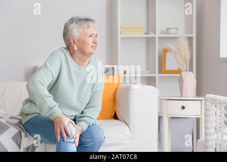 Donna anziana che soffre dal dolore nel ginocchio nel paese Foto Stock