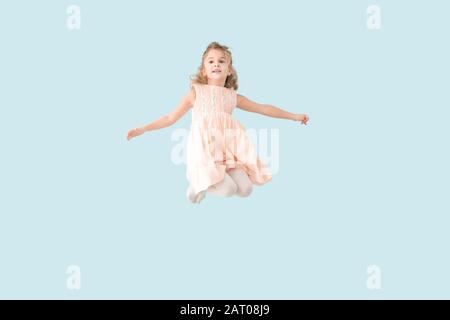 Jumping bambina sul colore di sfondo Foto Stock