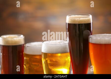 Bicchieri di birra saporita diversa su sfondo sfocato Foto Stock