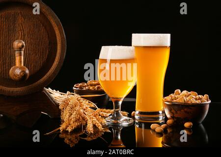 Composizione con birra fresca e spuntini a tavola Foto Stock