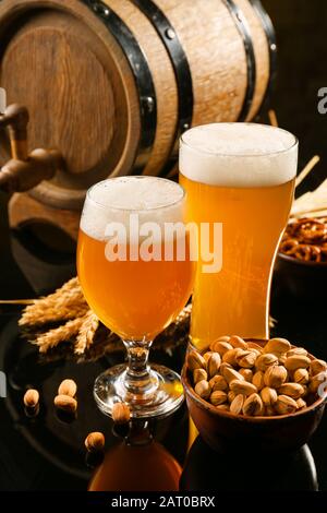 Composizione con birra fresca e spuntini a tavola Foto Stock