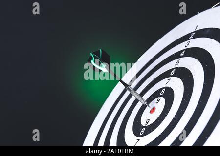 Dartdisegno con colpo bullseye su sfondo scuro, primo piano Foto Stock