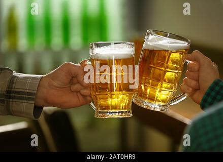 Gli amici a bere birra fresca in pub Foto Stock