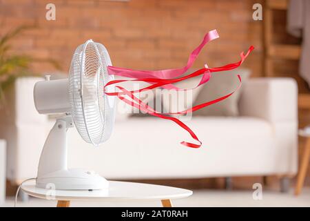 Ventilatore elettrico con nastri fluttering in camera Foto Stock