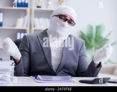 Imprenditore bendato lavoratore lavora in ufficio facendo di documenti cartacei Foto Stock