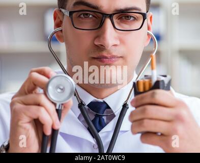 Il maschio di dottore in anti-fumo conceptwithcigarette pack Foto Stock