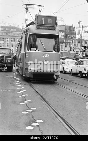 Applicando una nuova marcatura lungo il tram UN tram passa la marcatura della torta d'uovo che è applicata lungo il tram Data: 16 settembre 1968 Località: Leidseplein, Amsterdam, Noord-Holland Parole Chiave: Tram, sicurezza stradale Foto Stock