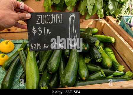 Firma scritta a mano sulla lavagna con il prezzo delle zucchine verde brillante sul mercato dell'agricoltore. Cibo fresco e genuino dalla campagna. Foto Stock