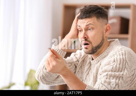 Uomo con la perdita di capelli problema a casa Foto Stock