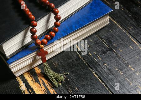 Croce cristiana e Bibbie su sfondo di legno scuro Foto Stock