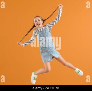 Jumping bambina sul colore di sfondo Foto Stock