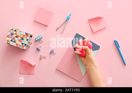 Palla da sforzo e cancelleria spremute a mano su sfondo a colori Foto Stock