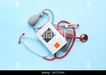 Sfigmomanometro elettronico e termometro su sfondo colorato Foto Stock