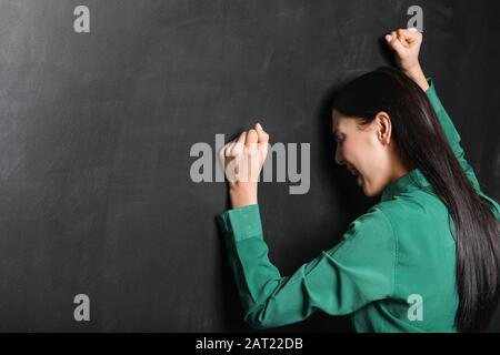 Insegnante femminile nella disperazione vicino al lavagna Foto Stock