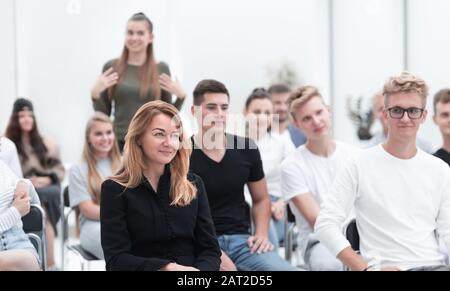 la giovane donna fa una domanda all'oratore durante il seminario. Foto Stock