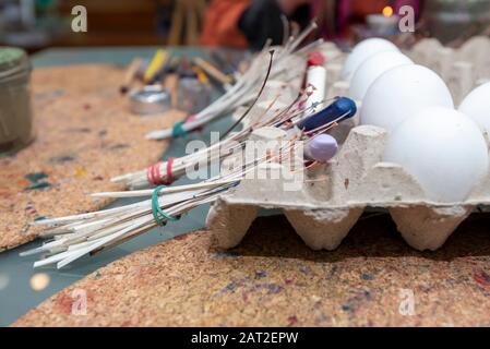28 gennaio 2020, Brandeburgo, Lübbenau: Nel laboratorio per le uova sorbiane a Lübbenau, i quills si appoggiano contro un pacchetto di uova. Le quills sono fatte di piume d'oca o di piccione. Sono necessari per tamponare i denti del lupo, le ruote del sole, i favi di miele e altri modelli tradizionali sulle uova di gallina bianca. I Sorbs in Lausitz sono famosi per la decorazione artistica delle uova di Pasqua. Foto: Stephan Schulz/dpa-Zentralbild/ZB Foto Stock