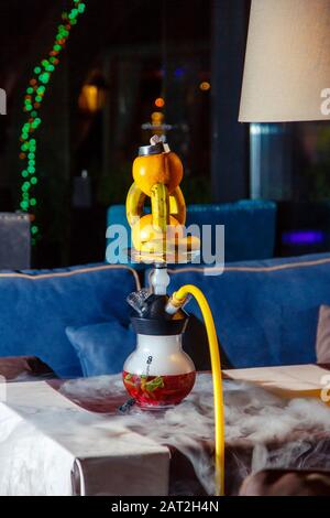 Hookah su arance e banane. Una ciotola di hookah consiste di due arance e tre banane stung sopra l'un l'altro. La fiasca di zoccoli è rotonda e tra Foto Stock