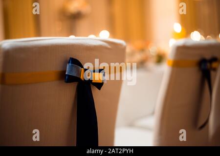 Le sedie sono decorate nella sala banchetti. Una sedia comoda ed elegante per un banchetto. Foto Stock