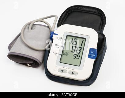 Misuratore elettronico della pressione sanguigna e bracciale in caso di necessità. Display del misuratore che mostra l'alta pressione sanguigna 151/98. Tracciato di ritaglio Foto Stock