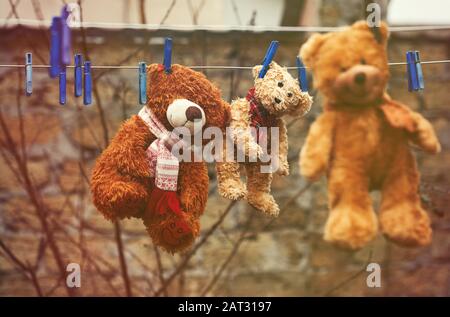 tre orsacchiotti marroni bagnati appesi su una stendibiancheria e che si asciugano all'aria fresca, tonificanti vintage Foto Stock