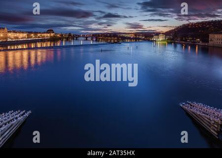 Praga, Repubblica Ceca - Vista Skyline della città di Praga dal Ponte Carlo al tramonto con nuvole blu e viola Foto Stock