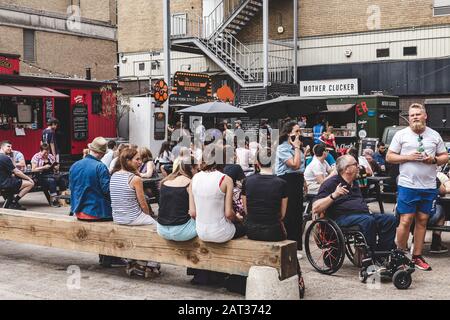 Londra/UK - 22/07/18: Persone che mangiano e socializzano nell'Old Truman Brewery's Ely's Yard di domenica, uno dei 5 mercati dei Truman Markets Foto Stock