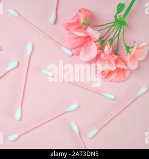 Prodotti per l'igiene: Il fiore di un geranio di colore corallo si trova sullo sfondo di un delicato colore corallo Foto Stock