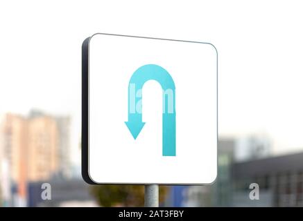 U-turn strada segno su sfondo urbano blurry Foto Stock