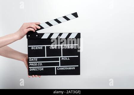 Film produzione clapper bordo nelle mani femminili contro uno sfondo bianco Foto Stock