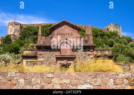 Bosa, Sardegna / Italia - 2018/08/13: Collina del Castello Malaspina - conosciuta anche come Castello di Serravalle - con facciata monumentale dello storico bacino idrico di Serbatoio di Bosa Foto Stock