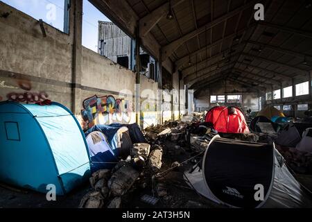 Immigrati curdi iracheni che si rifugiano in tende tra le macerie di un deposito derelict alla periferia di Dunkerque mentre cercano di raggiungere la Gran Bretagna. Foto Stock