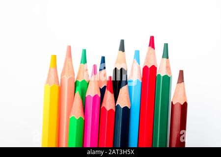 Mazzo di pastelli di matita colorati diversi isolato su uno sfondo bianco che è sfocato Foto Stock