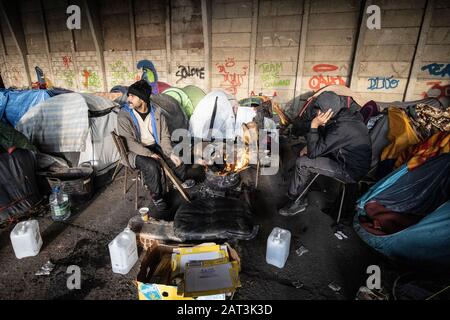 Immigrati curdi iracheni che si rifugiano in tende tra le macerie di un deposito derelict alla periferia di Dunkerque mentre cercano di raggiungere la Gran Bretagna. Foto Stock