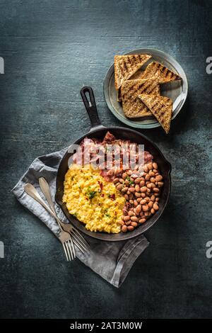 Colazione all'inglese uova strapazzate con pancetta e pane tostato alla griglia - vista dall'alto Foto Stock