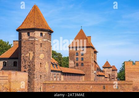 Malbork, Pomerania / Polonia - 2019/08/24: Vista panoramica del castello medievale dell'Ordine Teutonico a Malbork, Polonia - mura esterne di difesa, torri gemelle e torrette Foto Stock