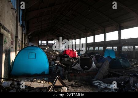 Immigrati curdi iracheni che si rifugiano in tende tra le macerie di un deposito derelict alla periferia di Dunkerque mentre cercano di raggiungere la Gran Bretagna. Foto Stock