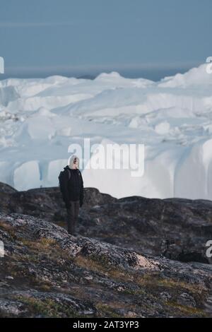 groenlandia turista uomo esploratore che si affaccia Icefjord in Ilulissat. Viaggia nella natura artica del paesaggio con iceberg. Persona turistica che guarda incredibile Foto Stock