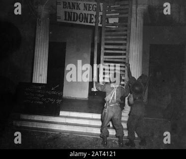 Le operazioni olandesi contro le autorità e le agenzie repubblicane nei soldati al buio rimuovono le porte dello schermo di un edificio con l'iscrizione Bank Negara Indonesia. Sulla sinistra c'è una lavagna sulla quale è scritto Malumat!!! Hari Saptu 19 Luglio 1947, Kantor Tutup. Sabato 19th Luglio 1947. Data: 19 Luglio 1947 Ubicazione: Batavia, Indonesia, Jakarta, Indie Orientali Olandesi Foto Stock